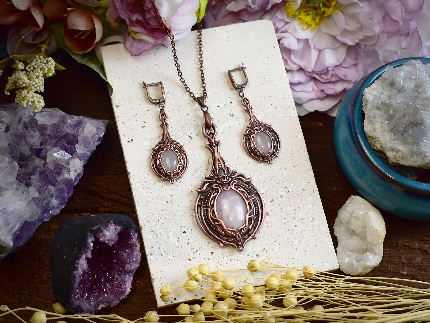 Close-up of rose quartz copper earrings showing oval pink gemstone and Victorian electroformed metalwork details
