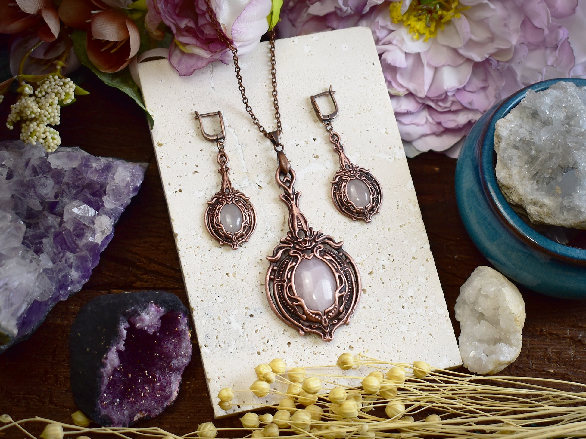 Close-up of rose quartz copper earrings showing oval pink gemstone and Victorian electroformed metalwork details