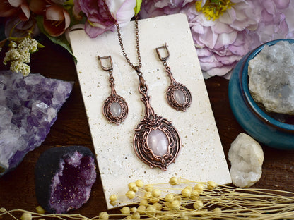 Close-up of rose quartz copper earrings showing oval pink gemstone and Victorian electroformed metalwork details